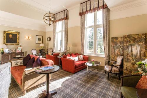 a living room with a red couch and chairs at Langrish House in Petersfield