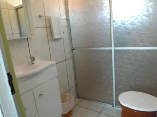 a bathroom with a shower with a toilet and a sink at Pousada Anjo Gabriel in Penha