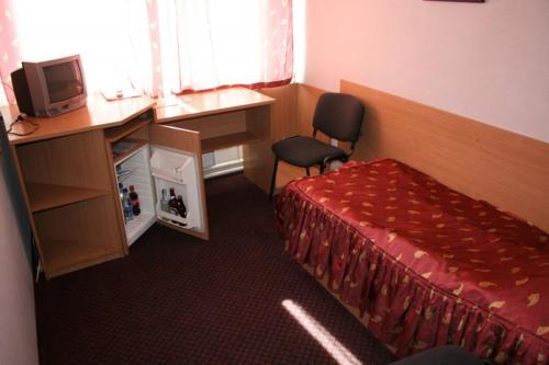 a room with a bed and a desk and a computer at Zhovtnevyi in Vinnytsya