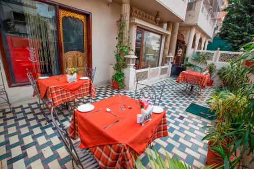 two tables with red table cloths on a patio at Nahargarh Haveli-Near Train station Metro in Jaipur