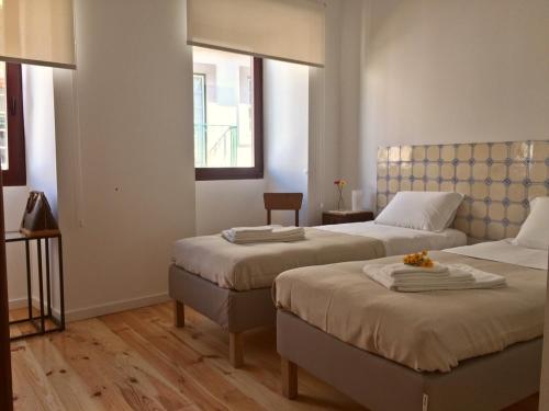 a hotel room with two beds and a window at Casa Amarela in Aveiro