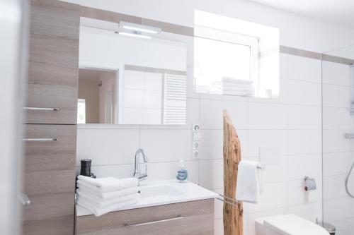 a white bathroom with a sink and a mirror at Kuckucksnest Todtnau-Muggenbrunn in Todtnau