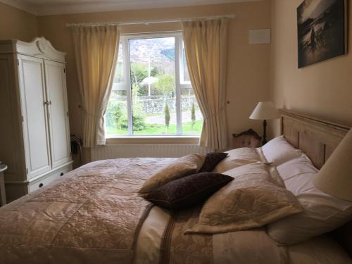 a bedroom with a bed with pillows and a window at Grove House Bed & Breakfast in Carlingford