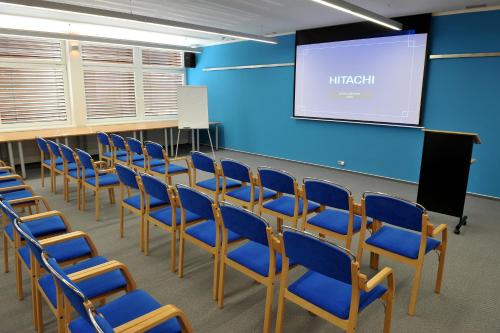 a lecture room with blue chairs and a screen at Hotel Břízky in Jablonec nad Nisou