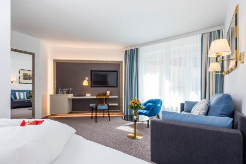フェルデン・アム・ヴェルターゼーにあるHotel Goritschniggのベッドとリビングルームが備わるホテルルームです。