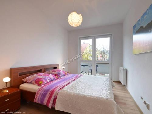 a bedroom with a large bed and a window at Apartamenty Iz-Mir in Kołobrzeg