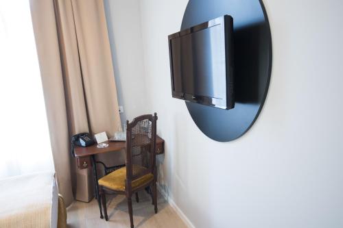 a mirror hanging on a wall with a chair and a desk at Hotel Ovo malo duše in Sarajevo