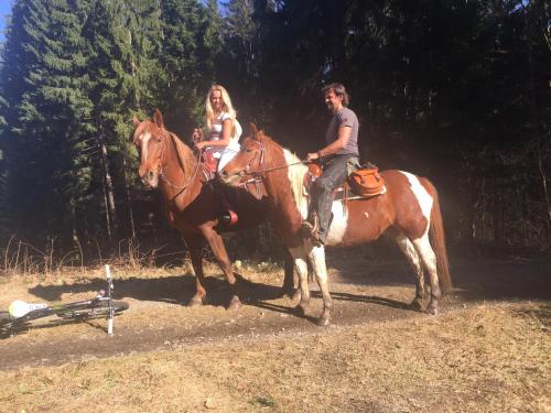 a man and a woman riding on horses at Penzion Farma Žleby in České Žleby