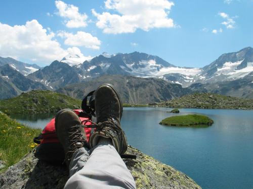 a person sitting on a rock overlooking a mountain lake at Ferienhaus Sternhof in Mieders