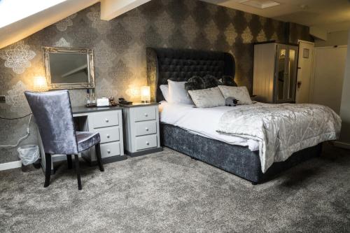 a bedroom with a bed and a desk and a chair at Best Western Wakefield Hotel St Pierre in Wakefield