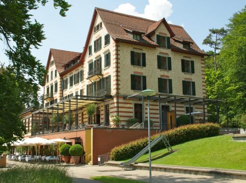 a large building with a slide in front of it at Sorell Hotel Zürichberg in Zurich