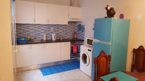 a kitchen with a refrigerator and a washing machine at Santo Cristo House in Ponta Delgada