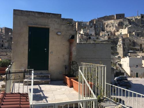 a building with a green door on a mountain at Terrazza Casa Mia Matera in Matera