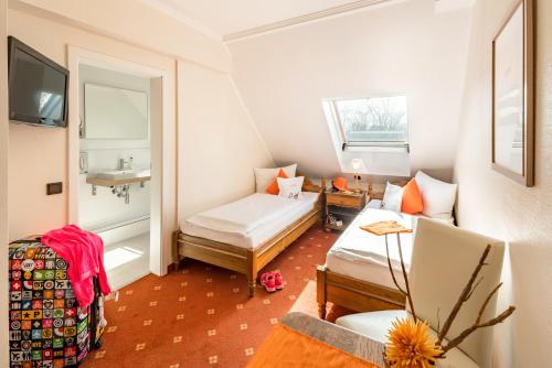 Kleines Zimmer mit 2 Betten und einem Waschbecken in der Unterkunft Airport Fashion Hotel in Düsseldorf