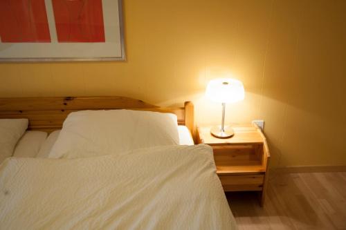 a bedroom with two beds and a lamp on a night stand at Hotel Gerig in Wassen