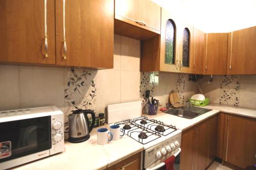 a kitchen with wooden cabinets and a stove top oven at A1 Hostel in Lviv