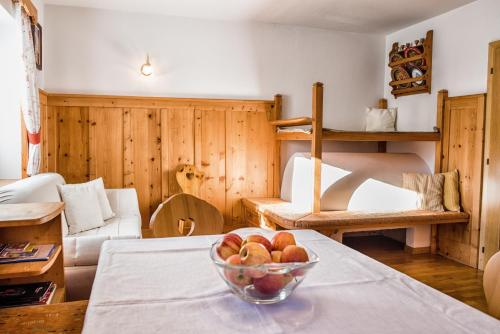 a living room with a bowl of fruit on a table at Pramulin in Selva di Val Gardena