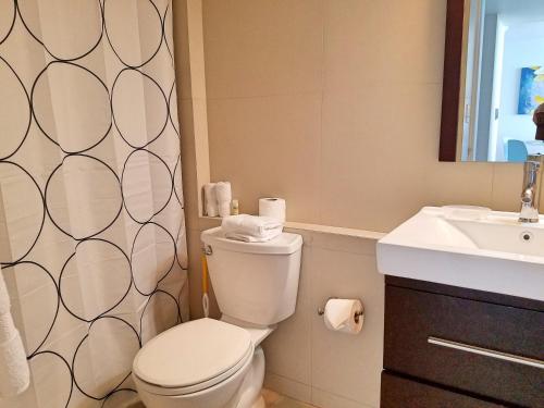 a bathroom with a toilet and a sink at Marbella del Caribe 1608 in San Juan