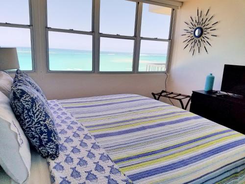a bedroom with a bed with a view of the ocean at Marbella del Caribe 1608 in San Juan