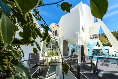 a white house with chairs on a balcony at Villamar Style Maison in Nazaré