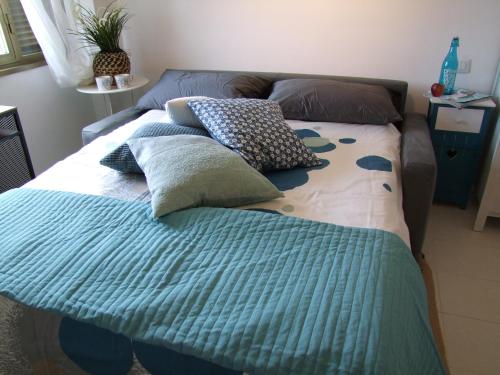 un letto con cuscini sopra in una camera da letto di Fly Windows Apartment a Ciampino