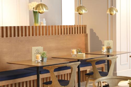 two tables in a restaurant with chairs and lights at Ciutat de Girona in Girona