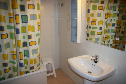a bathroom with a sink and a shower curtain at Apartamento Olimpo Orange Costa in Benicàssim