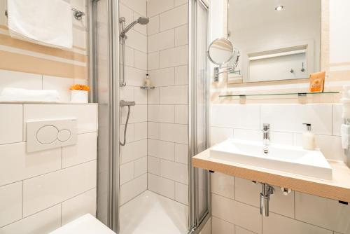 y baño con ducha y lavamanos. en Airport Fashion Hotel en Düsseldorf