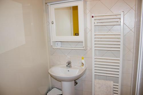 a white bathroom with a sink and a mirror at Agriturismo Ai Guiet in Superga