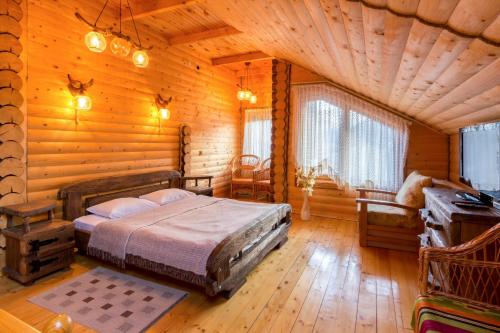 a bedroom with a bed in a log cabin at Panska Hata in Yaremche