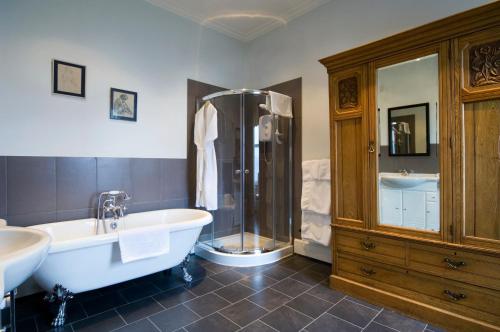 a bathroom with a tub and a shower and a bath tub at The Royal An Lochan in Tighnabruaich