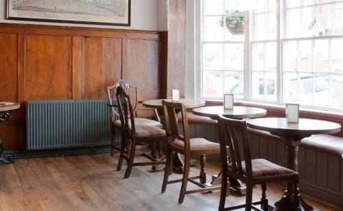 a dining room with tables and chairs and a window at The Green Dragon in Marlborough