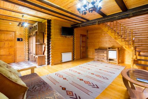 a living room with a rug on the floor in a log cabin at Panska Hata in Yaremche