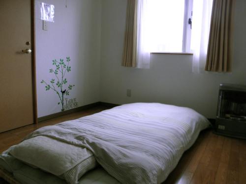 a bedroom with a bed in a room with a window at Guest House Annabel in Hakodate