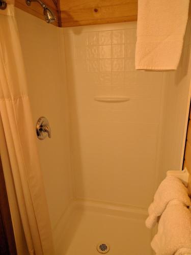 a bathroom with a shower with a tub at Emerald Forest Cabins in Trinidad