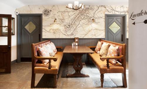 a restaurant with a table and two chairs and a map at The Green Dragon in Marlborough