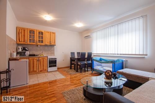 eine Küche und ein Wohnzimmer mit einem Sofa und einem Tisch in der Unterkunft Šišarka Apartmani Zlatibor in Zlatibor