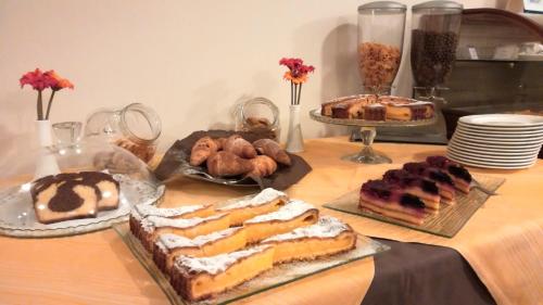 a table topped with different types of cakes and pastries at Hotel Majestic in San Giuliano Milanese