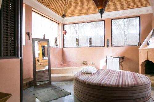 a bedroom with a large round bed and a tub at Lodge K in Marrakech