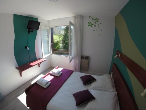 En eller flere senger på et rom på Hôtel Les Rives D'Allier