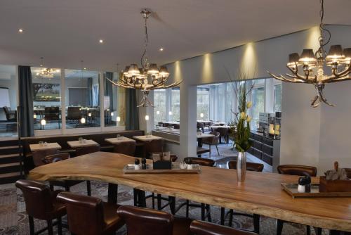 a restaurant with a large wooden table and chairs at Hotel Uhu Garni - Superior in Cologne