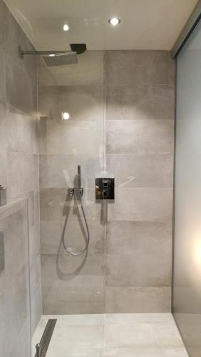 a bathroom with a shower with a glass door at Espaces d'Or in Wavre