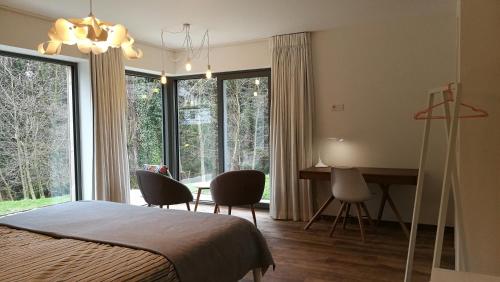 a bedroom with a bed and a desk and chairs at Espaces d'Or in Wavre