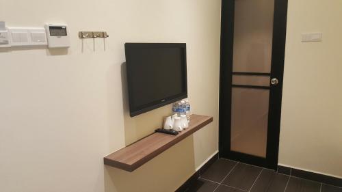 a room with a flat screen tv on a wall at 9 Square Hotel - Seri Kembangan in Seri Kembangan