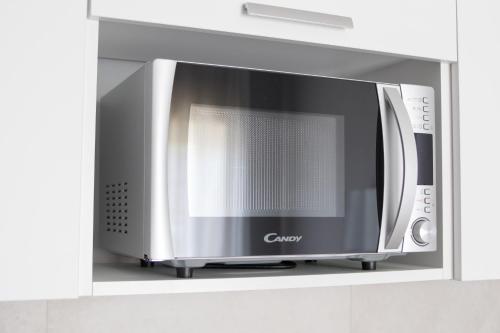 a microwave oven on a shelf in a kitchen at Alludo Aparthotel b&b in Agrigento