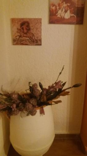 a white vase filled with flowers in a room at Eleni Studios in Agios Nikolaos