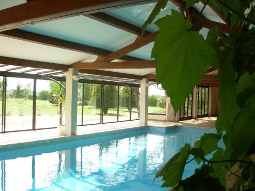 a swimming pool in a house with a roof at Domaine du Griffier in Granzay