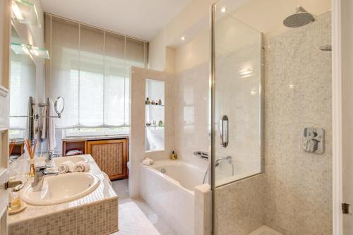 a bathroom with a tub and a sink and a shower at La Gaura Guest House in Casal Palocco