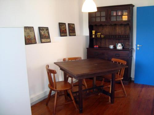 uma sala de jantar com uma mesa de madeira e cadeiras em Casa do Jasmim em Sintra