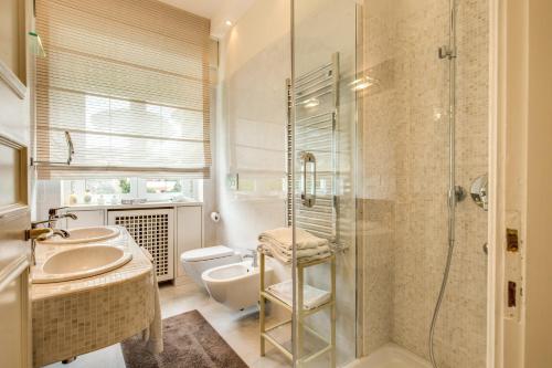 a bathroom with a shower and a sink and a toilet at La Gaura Guest House in Casal Palocco